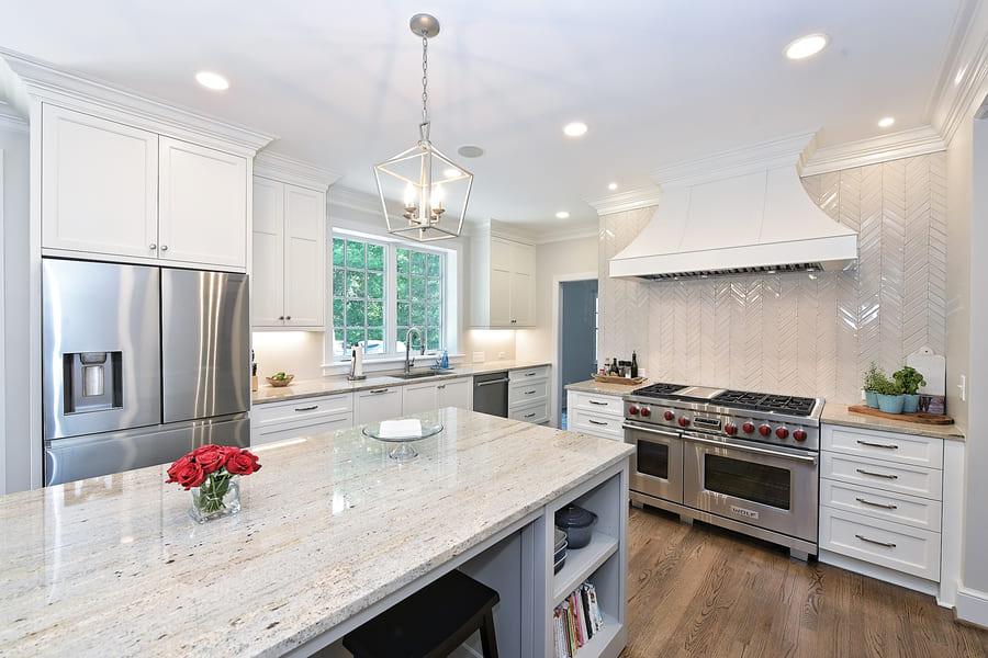 Kitchen with white countertops  on island and brown floors by Hopedale Builders  in charlotte nc